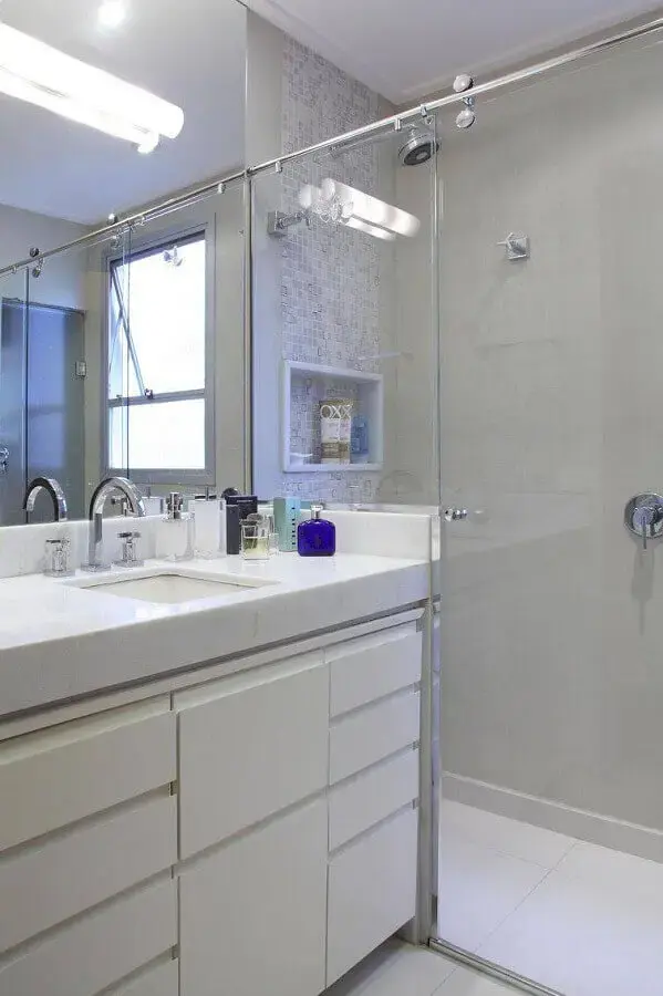 banheiro pequeno planejado com armário branco e box de vidro Foto Cris Paola Arquitetura