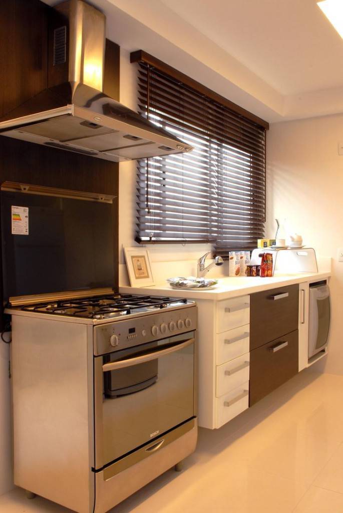 Cozinha pequena decorada com paredes, piso e móveis em tons claros