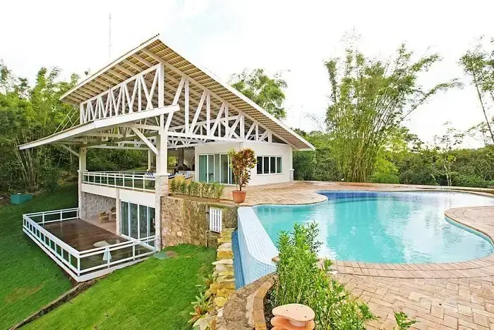 Casa com estrutura metálica branca e piscina com pastilhas