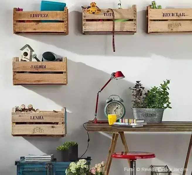 Decoração com caixotes de madeira usados como nichos e em cada um há o nome do que está dentro, como "limpeza, "reciclar", dentre outros Foto de Nadine Guerra