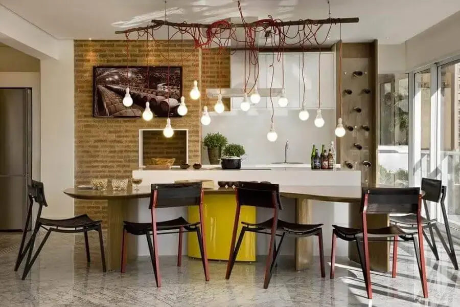 cozinha gourmet decorada com pendentes modernos parede de tijolinhos e bancada de cozinha em madeira Foto Léo Romano