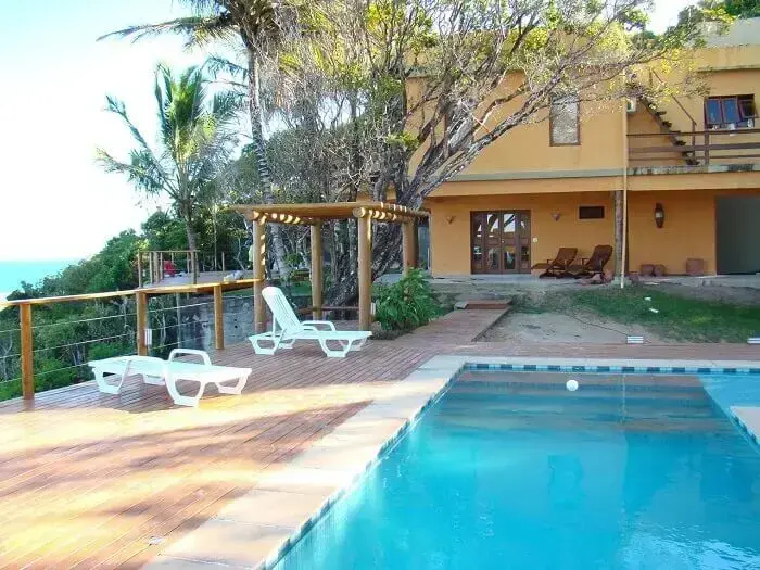 Área externa com piscina e deck de madeira