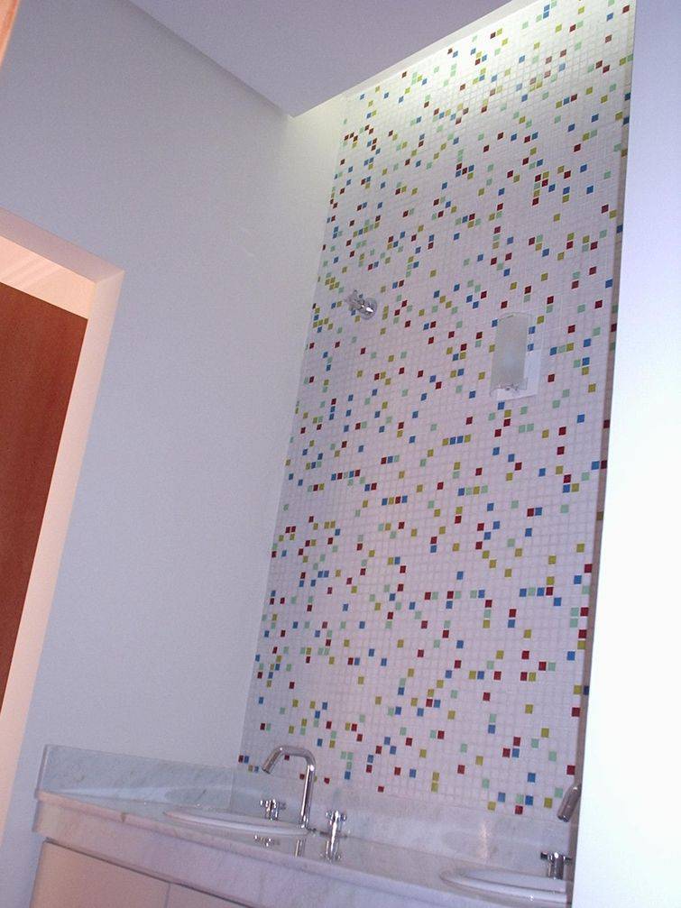 Banheiro com pastilhas brancas e pontos coloridos
