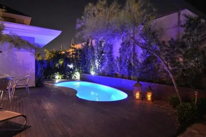 Área externa com piscina pequena iluminada e deck de madeira Projeto de Paulinho Peres