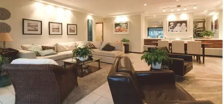 O sofá de canto branco limita a área da sala de estar