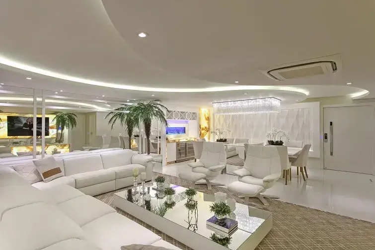 Sala de estar decorada com sofá de canto e móveis claros