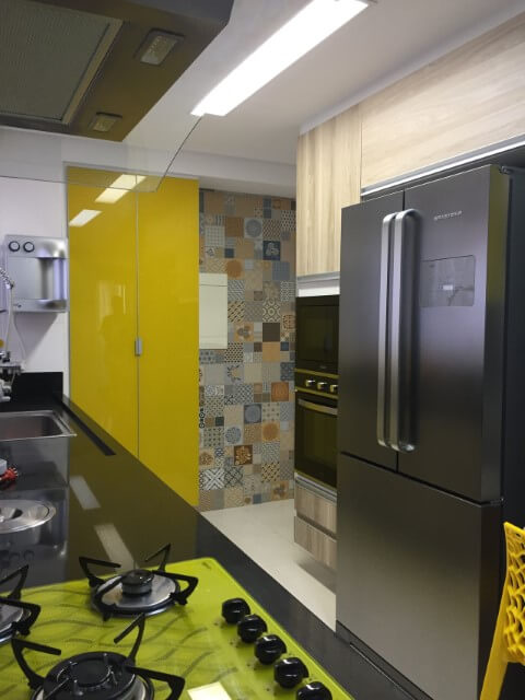 Cozinha colorida com toques amarelados e azulejos Projeto de Marcia Rubinatti