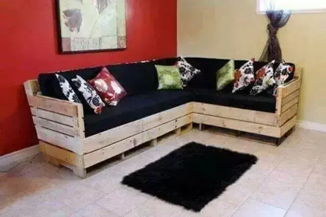 Sofá de palete com almofadas pretas e estampadas