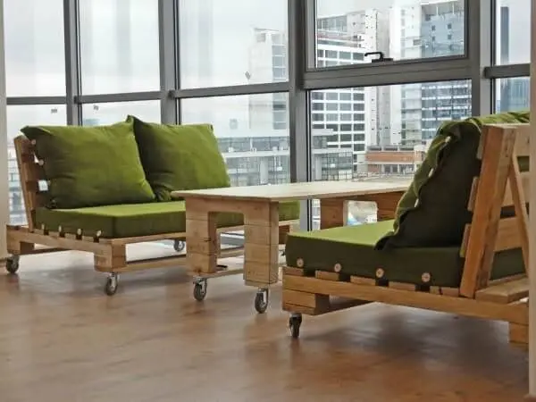 Sofá de palete com rodinhas e almofadas verdes
