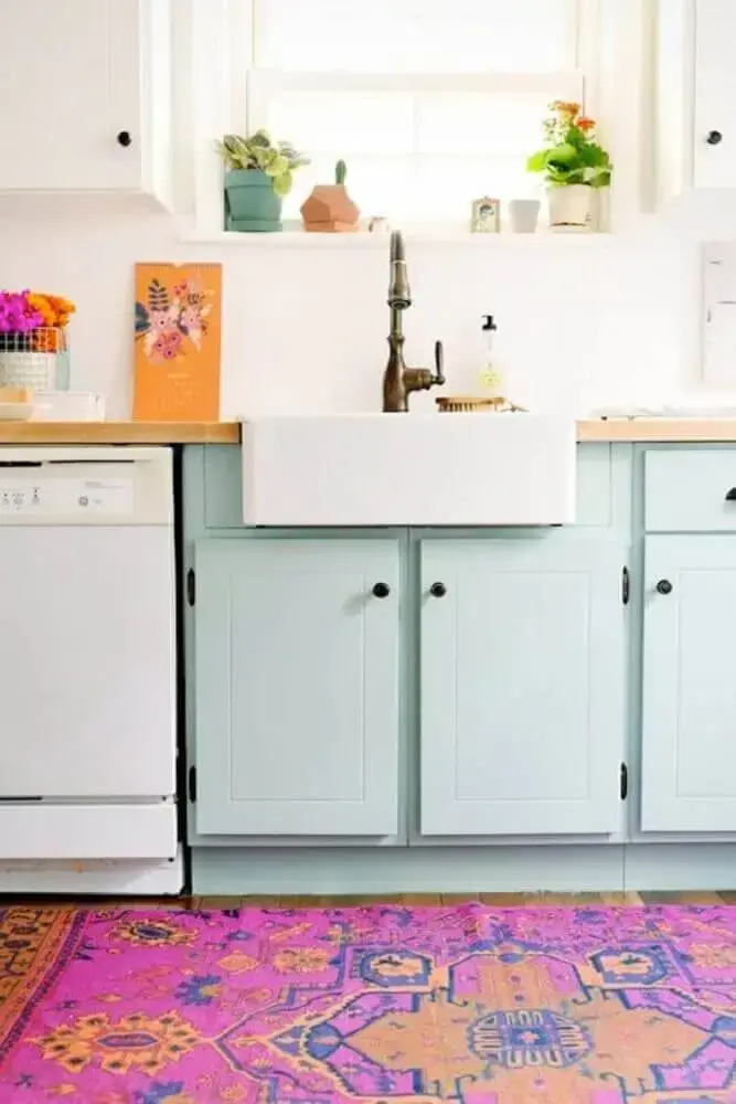 cozinha colorida com tapete rosa e armário azul Foto Brit + Co