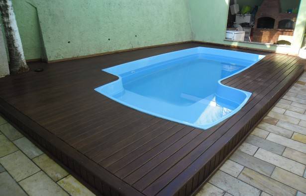 piscina de fibra com deck de madeira retangular