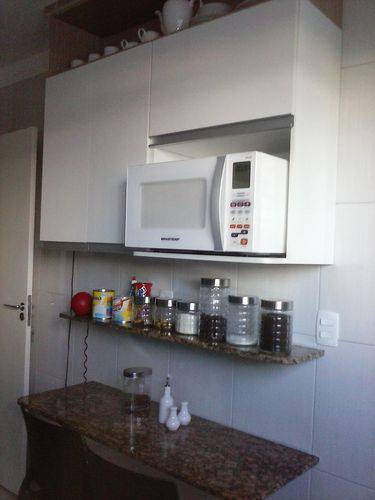 Cozinha compacta com armário aéreo branco e bancada de granito Projeto de Madik Correia Dutra