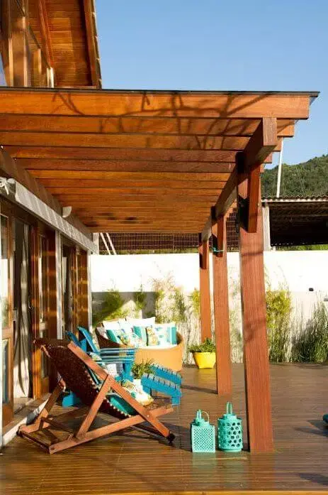 Varanda de casa de praia com pergolado de madeira Projeto e Espaço do Traço