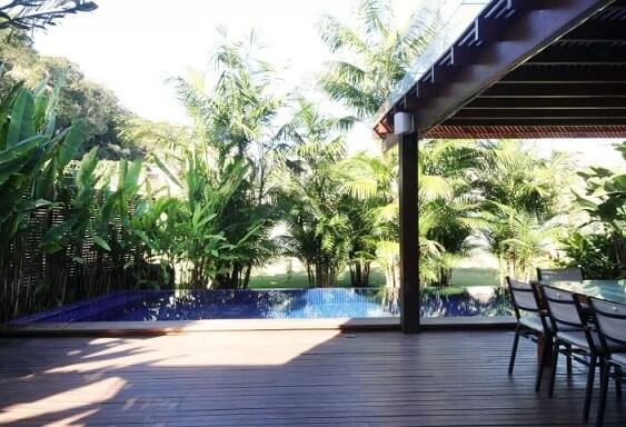Varanda gourmet com deck e pergolado de madeira perto da piscina Projeto de Rawi Arquitetura