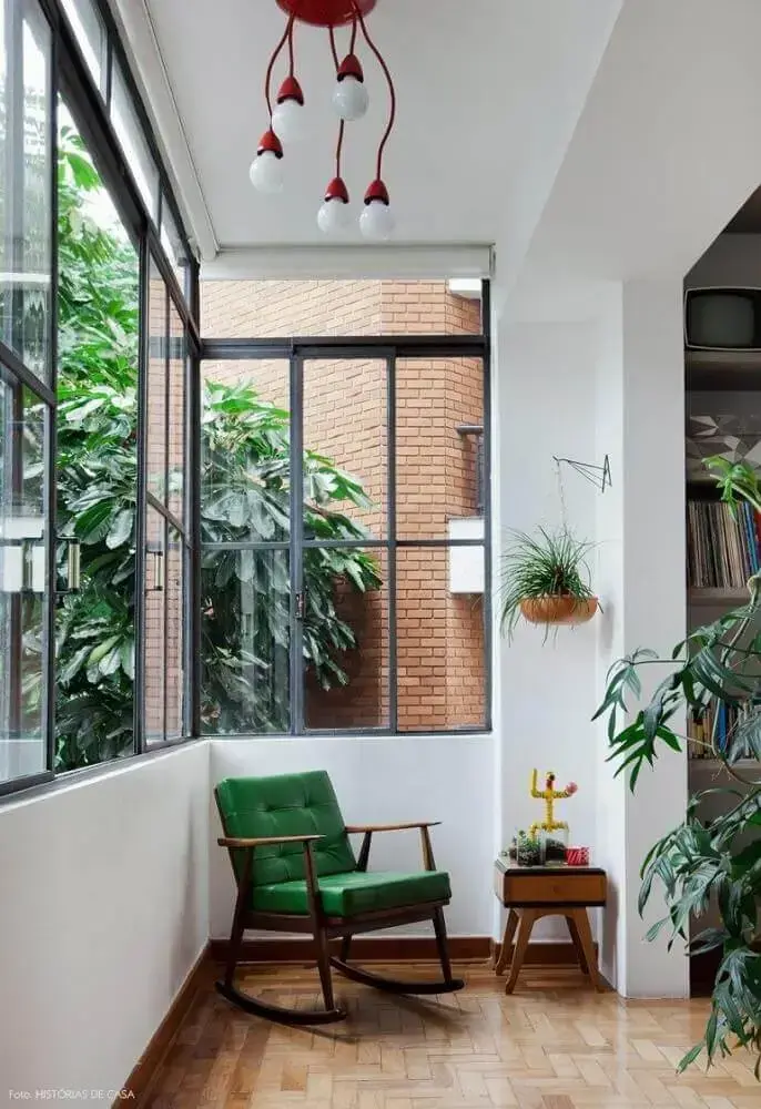 decoração cantinho da leitura na varanda com poltrona de balanço verde e vasos de plantas Foto Pinterest