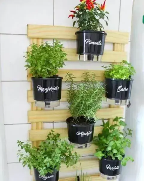 Horta vertical com vasos autoirrigáveis em treliça de madeira Foto de MSN