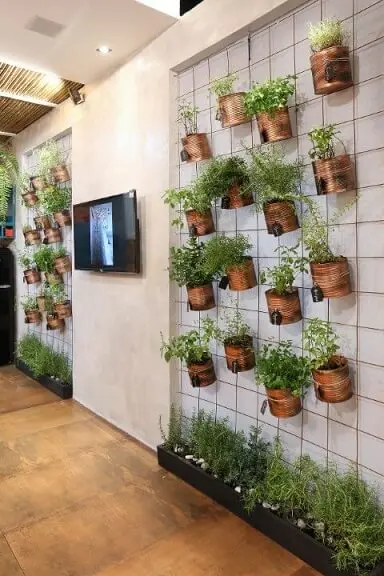 Horta vertical em treliça com potes de metal Projeto de Ana Cano Milman