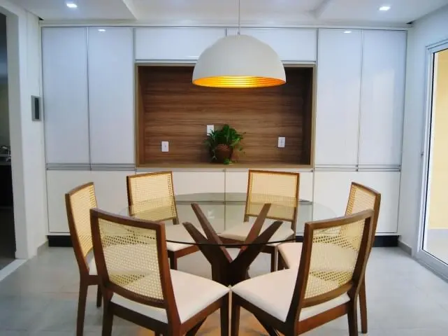 Mesa redonda de vidro com 6 cadeiras e luminária arredondada Projeto de Priscila Fernandes