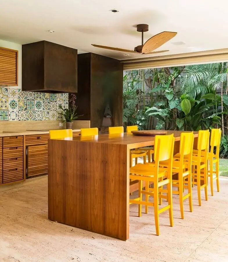 cores quentes para varanda gourmet com móveis de madeira e banquetas amarelas  Foto Marina Linhares Interiores