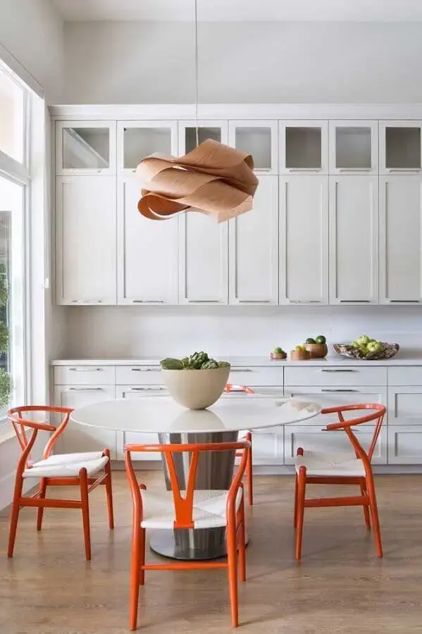 decoração de cozinha branca com cadeiras laranjas e mesa redonda  Foto Krista + Home