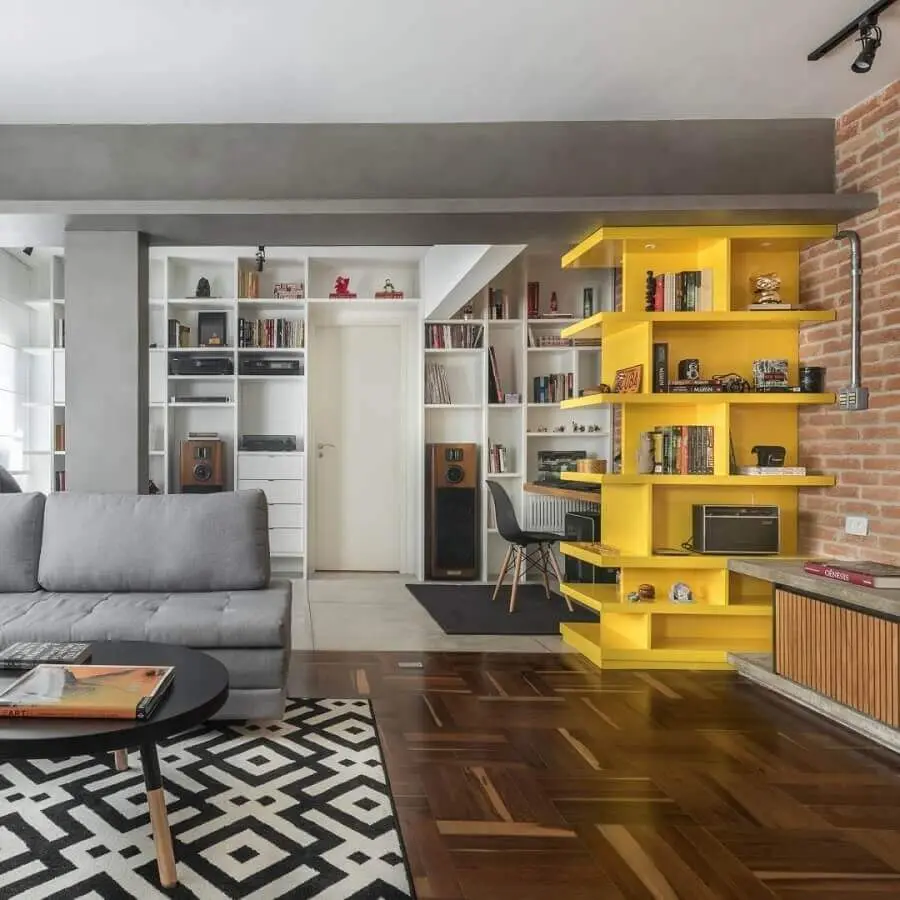 decoração para sala com parede de tijolinho e estante amarela  Foto Fernanda Dabbur Arquitetura e Interiores