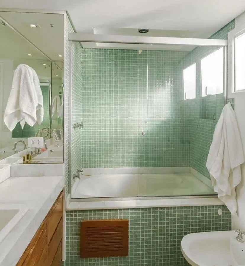 pastilhas de vidro verde para banheiro com banheira e armário de madeira Foto Fernanda Duarte Inteiores
