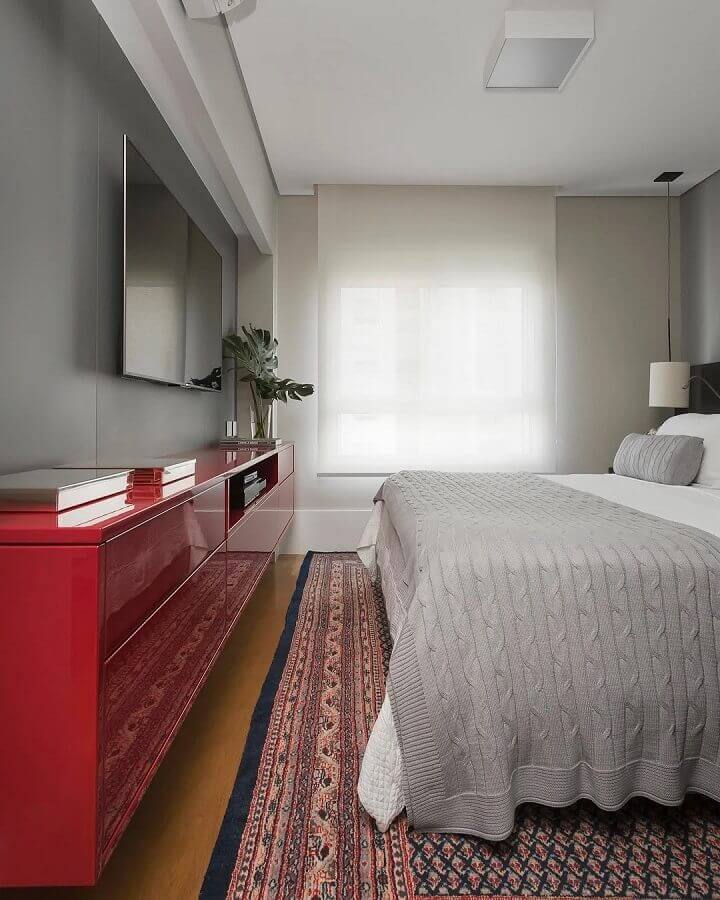 quarto cinza decorado com rack suspenso vermelho  Foto Quattrino Arquitetura