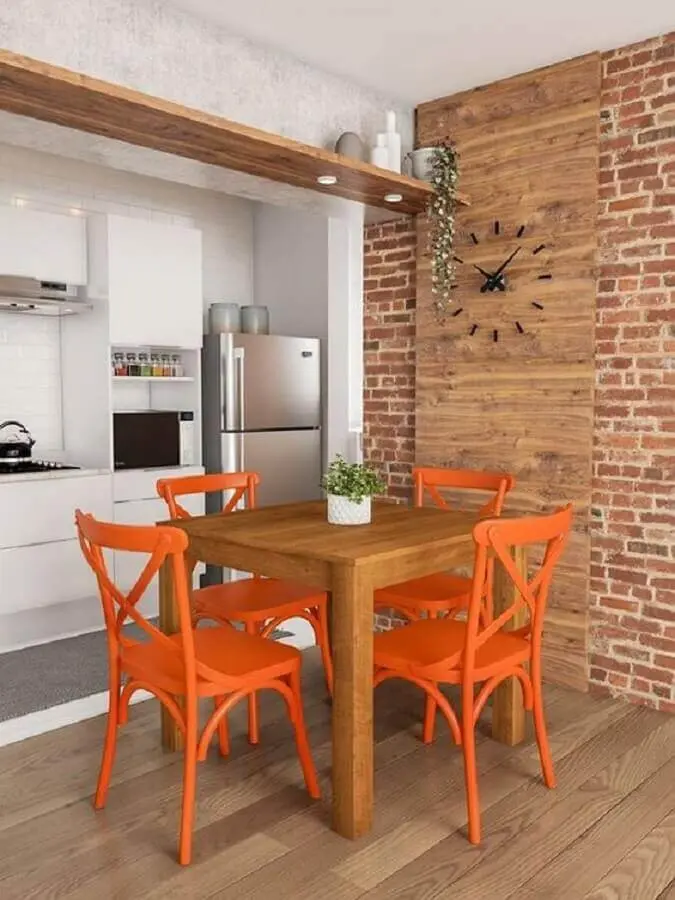 sala de jantar decorada com cadeiras laranja e parede de tijolinho Foto Histórias de Casa
