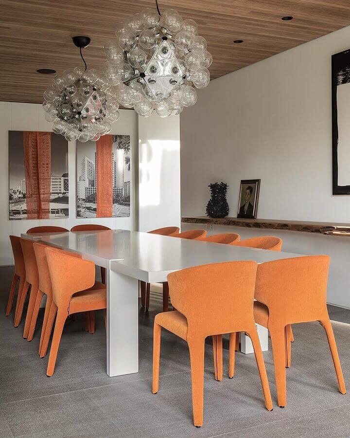 sala de jantar decorada com lustre pendente moderno e cadeiras estofadas laranjas  Foto Sala 2 Arquitetura e Design