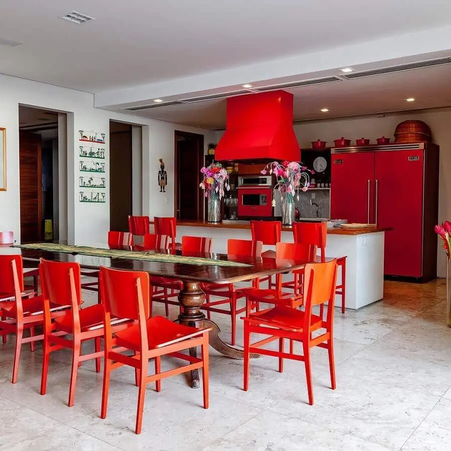 varanda gourmet decorada com cadeiras e armários vermelhos  Foto DB Arquitetos