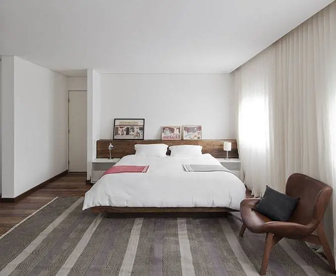 A integração de quartos fez com que a área de suíte aumentasse. O chão em madeira de demolição integra visualmente os ambientes.