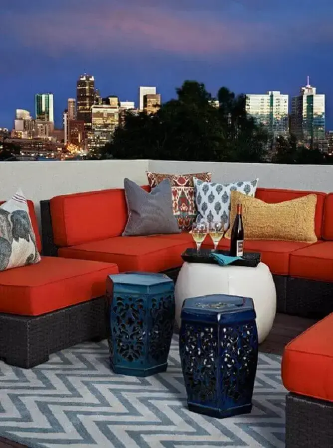 área externa decorada com sofá vermelho e garden seat azul Foto Idées de Décoration