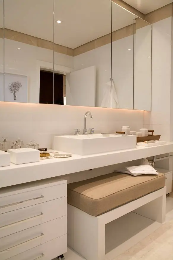 Banheiro do quarto do jogador de futebol Cafu, trabalhado com uma paletra branca e com espelhos para dar uma sensação de ampliação do ambiente.