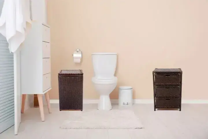Banheiro simples com piso vinílico claro e móveis de vime Projeto de Rerisson Faria Lima