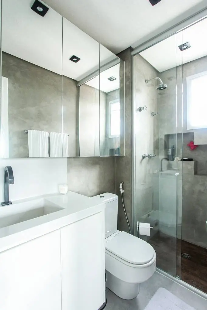 No banheiro, o décor é bem clean e neutro, marcado por cimento queimado e cores brancas
