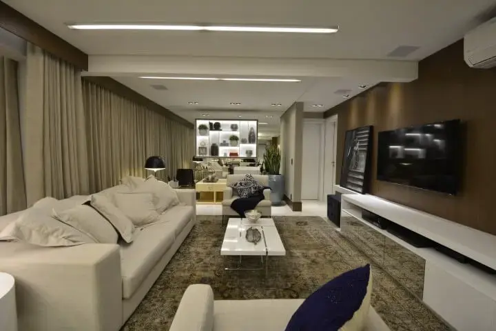 Sala de TV com móveis brancos e tons terrosos Projeto de Maira Ritter