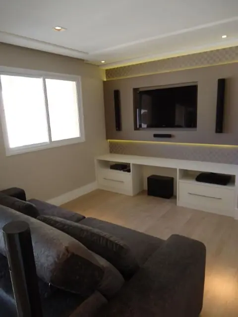Sala de TV com painel com iluminação de LED Projeto de Claudiana Ressi