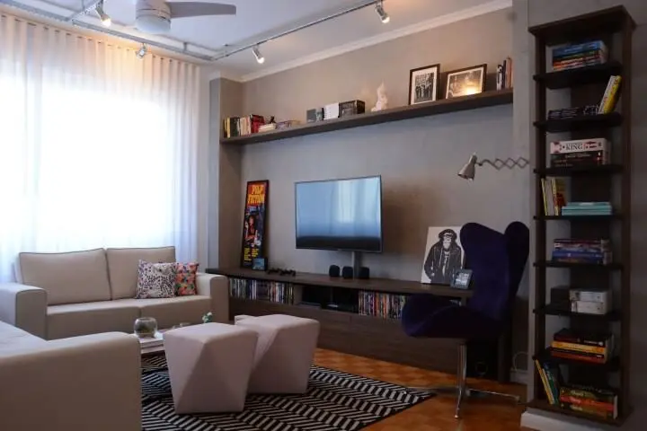 Sala de TV com parede de cimento queimado e decoração moderna