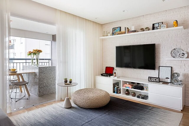 Sala de TV com parede de tijolinhos brancos e com home theater Projeto e Doob Arquitetura