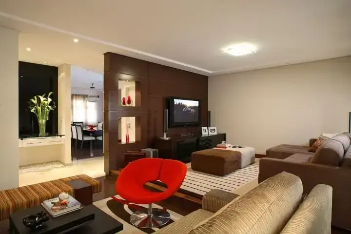 Sala de TV integrada com decoração neutra e toques de vermelho Projeto de Claudia Arakaki