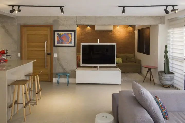 Sala de TV integrada com painel giratório Projeto de Galpão Design