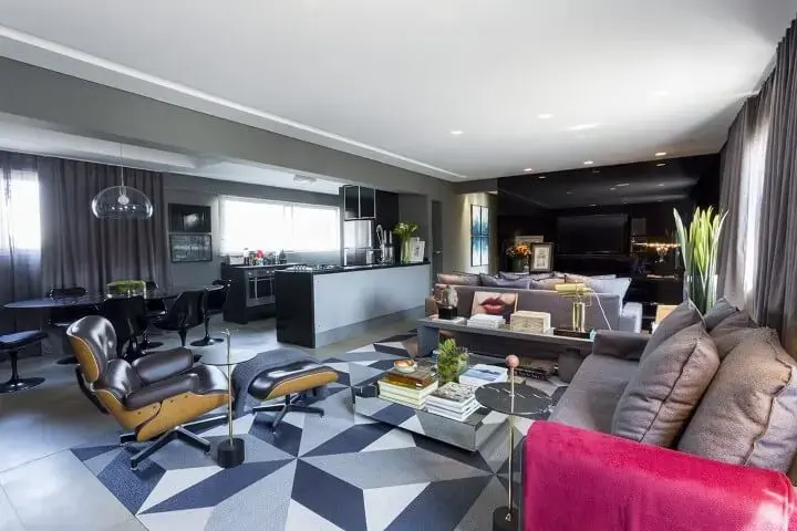 Sala de TV integrada à sala de estar com painel preto Projeto de Triart Arquitetura