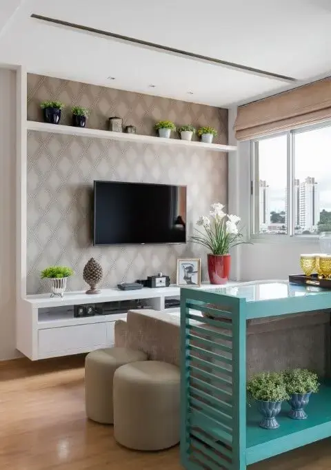 Sala de TV neutra com móvel turquesa atrás do sofá Projeto de Cláudia Comparin
