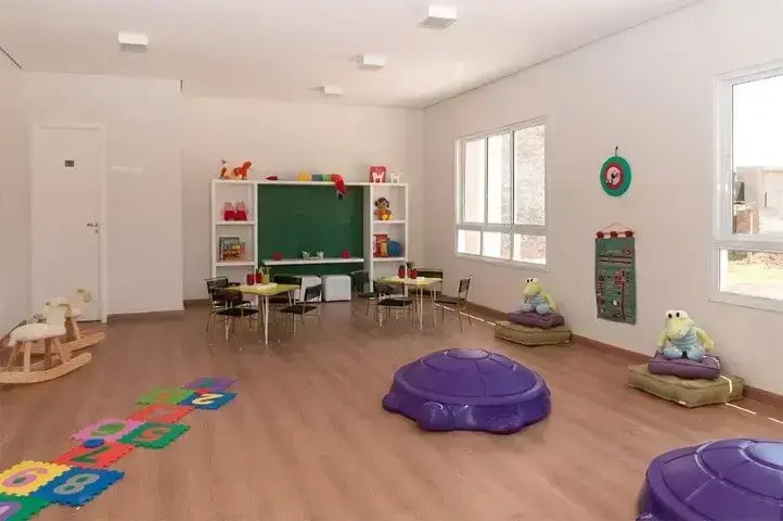 Sala de brinquedos com piso vinílico e brinquedos roxos Foto de Tecnisa