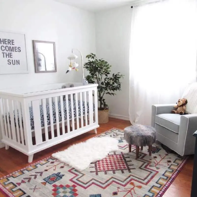 decoração simples com poltrona cinza e tapetes para quarto de bebê branco Foto PopSugar