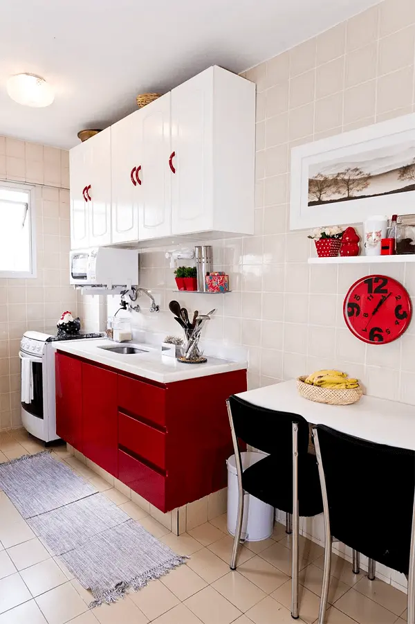 A bancada da cozinha vermelha se harmoniza com os armários brancos