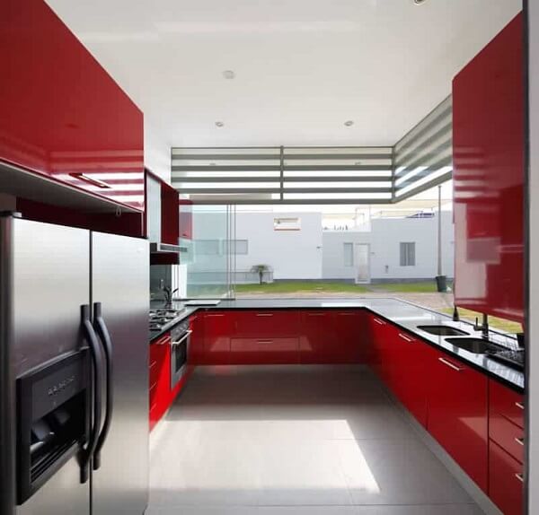 A geladeira de inox se encaixa perfeitamente nessa cozinha vermelha