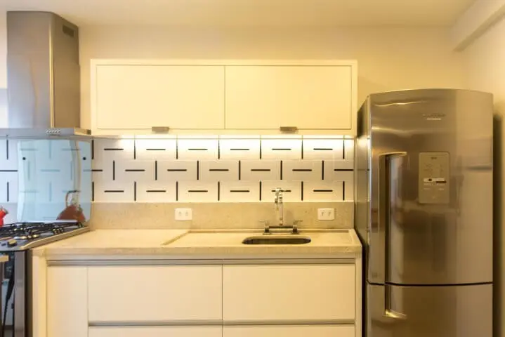 Armário de cozinha de parede branco Projeto de Tria Arquitetura