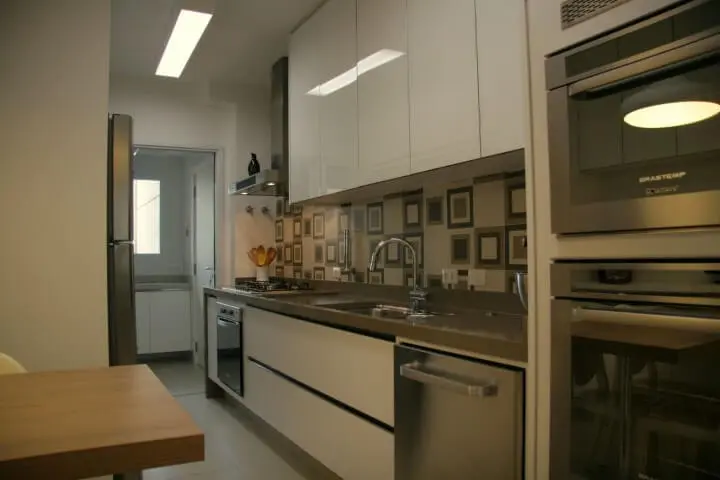 Armário de cozinha de parede branco em ambientes integrados Projeto de Moussi Arquitetura