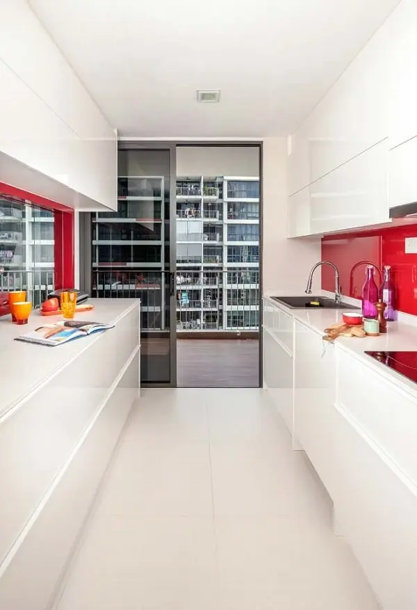 Cozinha branca com pontos em vermelho entre o vão do armário e da bancada